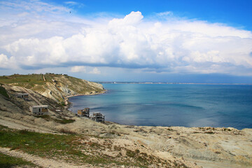 Obraz premium A deserted beach with abandoned buildings and a city in the distance