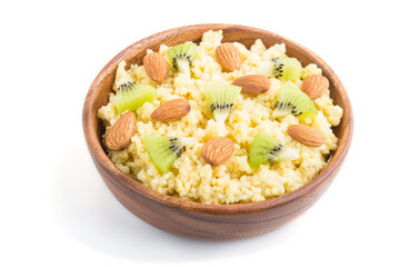 Millet porridge with kiwi and almonds in wooden bowl isolated on white background. Side view.