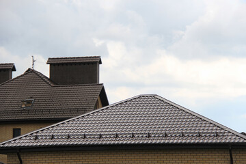 roof with new brown roofing tiles on residential property. banner on  roof for roofers. concept for...