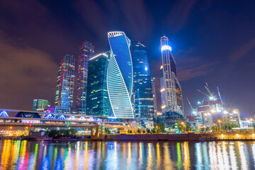 Fototapeta na wymiar Moscow skyline panorama at night with colorful lights reflections on the surface of the river Moskva. Modern type of buildings for business, social life, and accommodation. Amazing at blue hour time. 