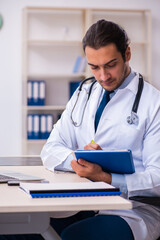 Young male handsome doctor working in the clinic