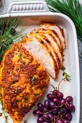 Christmas roasted turkey breast with grapes in black dish, top view. Christmas food concept.