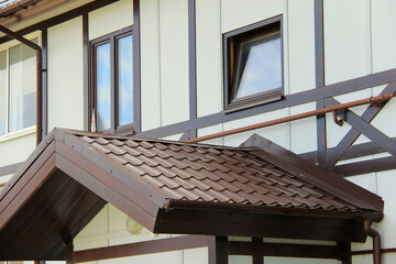 roof with new brown roofing tiles on residential property. banner on  roof for roofers. concept for...