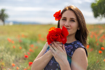 Girl in a blue dress at a poppy flower garden