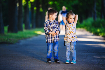 Obraz premium Children's love, a little boy and a girl, having fun, laugh and smile, and kiss outdoors