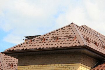 icon roof with new brown roofing tiles on residential property. banner on  roof for roofers....