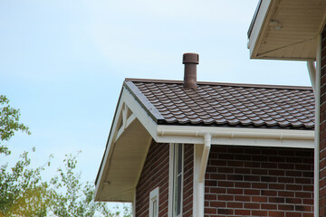 icon roof with new brown roofing tiles on residential property. banner on  roof for roofers....