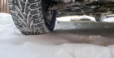 Fototapeta na wymiar Car tires on winter snowy road