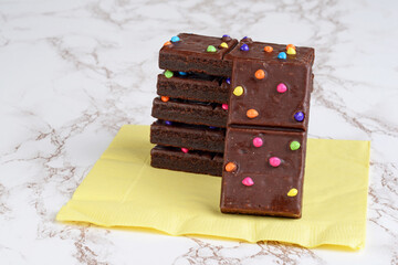 stack of chocolate fudge brownies on yellow napkin