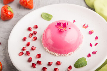 Pink mousse cake with strawberry on a gray concrete background. side view, selective focus.