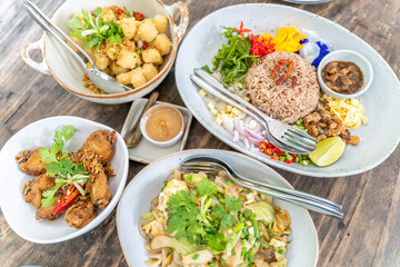 Set of Thai food including seasoning rice, fried chicken wings, deep fried tofu, and noodle