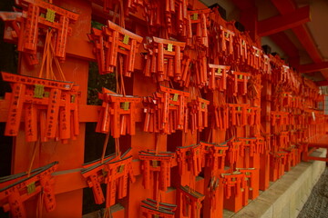 Red and black torii gates are lined up at shrine in Kyoto, Japan