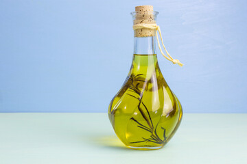 glass bottle of olive oil with a sprig of rosemary