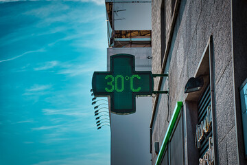30 degrees celsius, 86 fahrenheit is the temperature displayed by a digital thermometer on a hot summer outside a pharmacy in Milan - obrazy, fototapety, plakaty