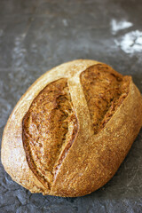Loaf of country sourdough bread on a dark background, close-up