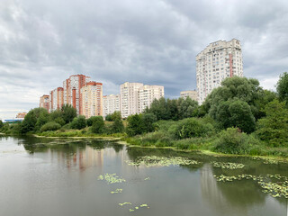 Fototapeta na wymiar Moscow region, the city of Balashikha. Pekhorka river in summer and view of Zarechnaya street in cloudy weather