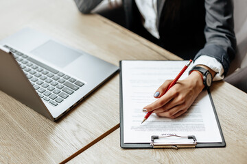 Young girl office worker or business lady signs documents. Concentrated businesswoman working with papers. Business concept