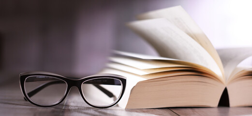 Composition with glasses and open book on the table