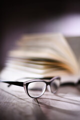 Composition with glasses and open book on the table