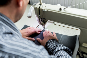 Designer tailor sew seat covers. Man use sewing machine for his work.