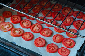 Baking sheet with chopped tomatoes in the oven.