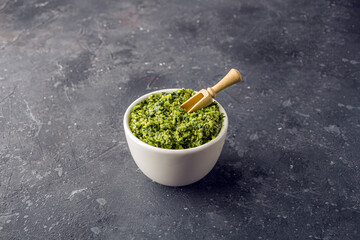 Fresh Cooked Traditiona Italian sauce Pesto and Basil leaves on dark background. Copy sapce for text