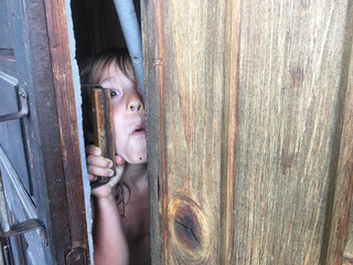 frightened child looks out of the  doorway