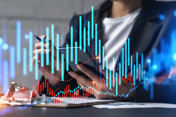 Businesswoman taking notes using smart-phone. Financial forex graph and chart hologram double exposure.