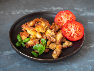 Snack and fried chicken fillet and red tomatoes, green basil