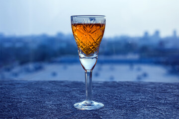 Orange alcoholic liqueur, tincture with herbs in a shot glass. Summer refreshing cocktail drink with orange peel. Copy space for text