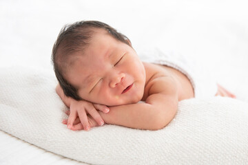 Fototapeta na wymiar Asian newborn baby sleeping in white blanket. portrait of a beautiful asleep infant baby on white.