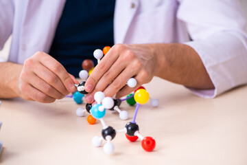 Young male scientist sitting in the classroom