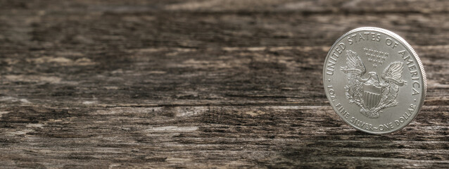 Web / Banner: Silbermünze (1 Oz American Silver Eagle) auf verwitterten alten Holz