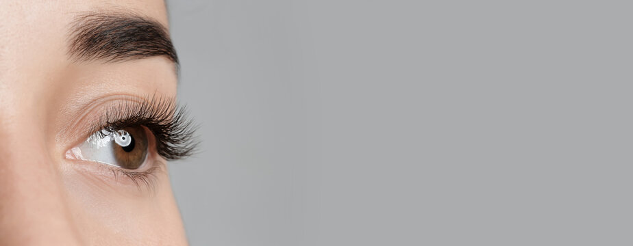 Closeup View Of Young Woman With Beautiful Long Eyelashes On Grey Background, Space For Text. Banner Design