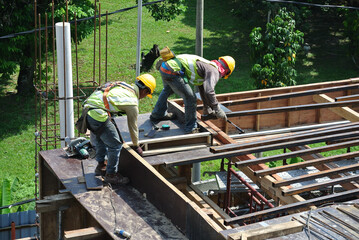 MALACCA, MALAYSIA -MARCH 25, 2016: Construction workers fabricating timber form work at the construction site in Malacca, Malaysia. The form work was mainly made from timber and plywood. 