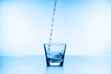 water splashing from glass isolated on blue background