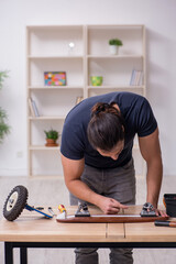 Young male repairman repairing skateboard