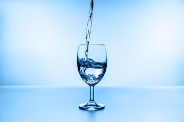 water splashing from glass isolated on blue background