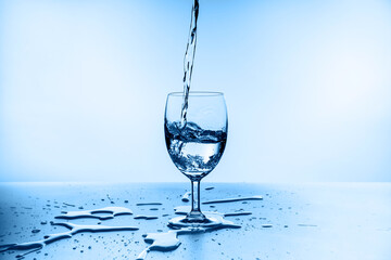 water splashing from glass isolated on blue background