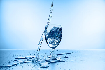 water splashing from glass isolated on blue background