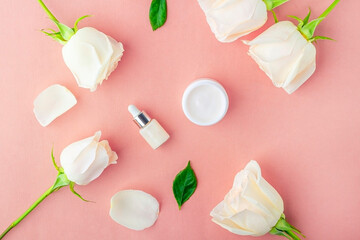 Natural organic homemade cosmetics concept. Skin care (therapy), beauty products: containers with face cream and serum among delicate rose flowers petals.Flat lay, top view, mock up