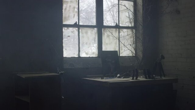 Work bench in front of industrial windown in warehouse with random objects strewn throughout space