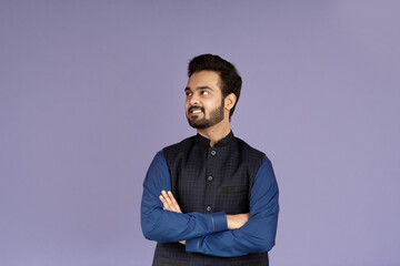 Obraz premium Positive Indian guy standing with crossed arms on lilac background