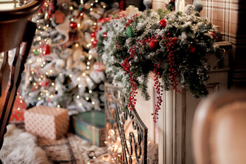Christmas decorations. Home interior in pastel colors. Holiday fireplace with pine cones and snow fir branches. Multi-colored bokeh in the background. Selective focuse.