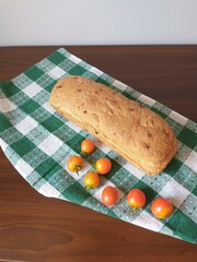 on a green napkin is freshly baked bread, next to it are red cherry tomatoes