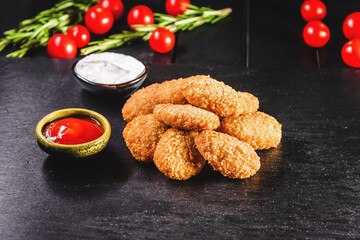 Chicken fried nuggets on a dark background. Fast food concept