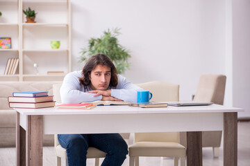 Young male student preparing for exams at home