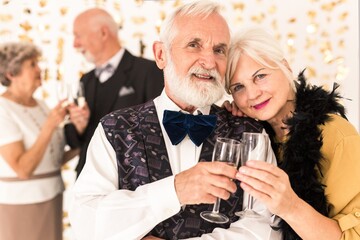 Cute elegant senior couple toasting with champagne during New Year's Eve - Powered by Adobe