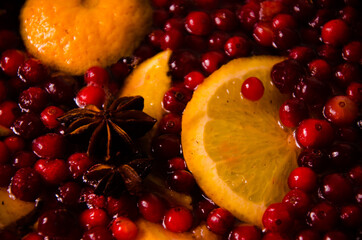 metal pot on the stove. Oranges and cranberries in mulled wine