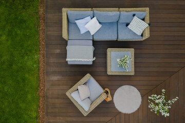 Top view of wooden terrace with comfortable wicker garden furniture